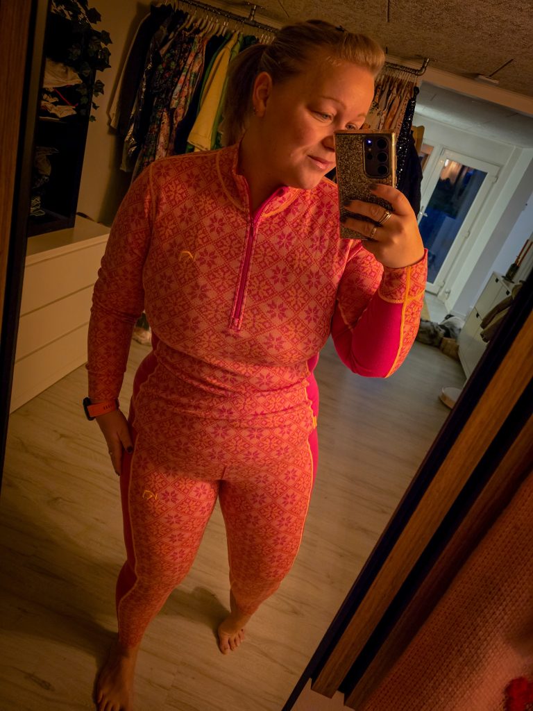 Woman wearing a colourful plus-size merino wool base layer for hiking and outdoor adventures.