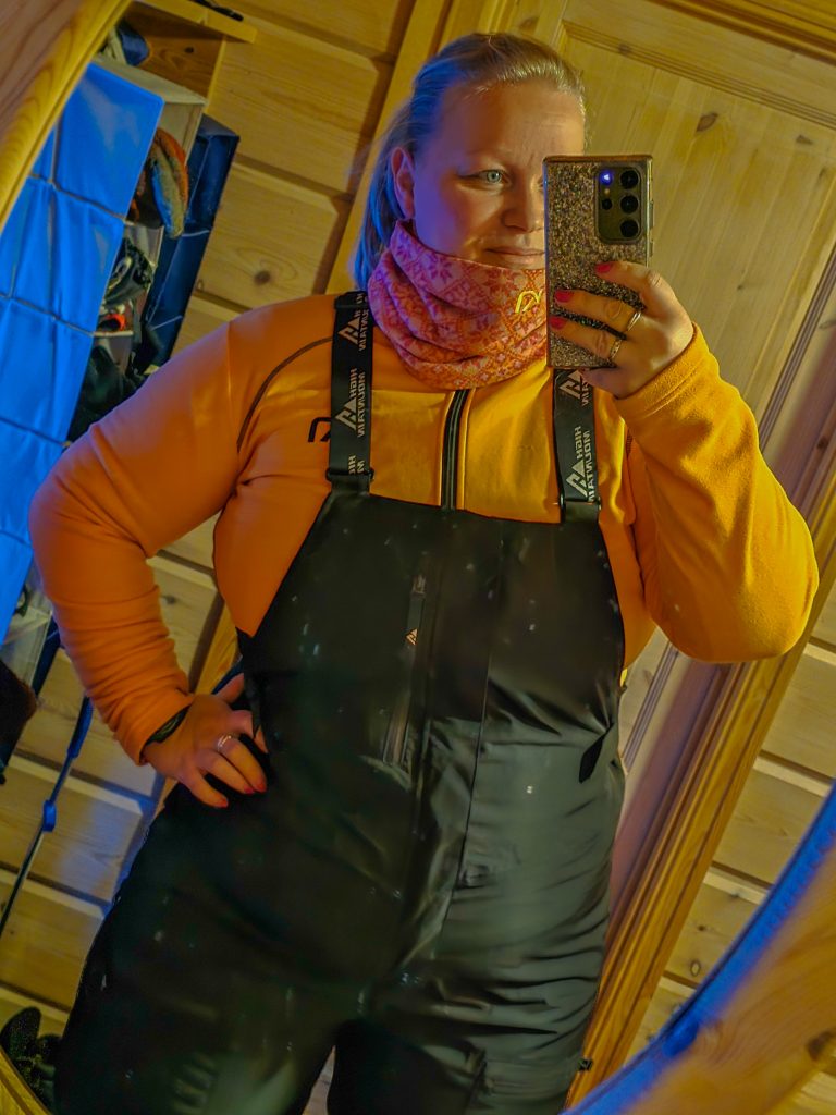 Woman wearing insulated outdoor clothing and bib trousers for a winter adventure.