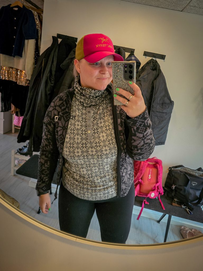 Woman wearing layered hiking clothes for a day outdoors in Denmark.